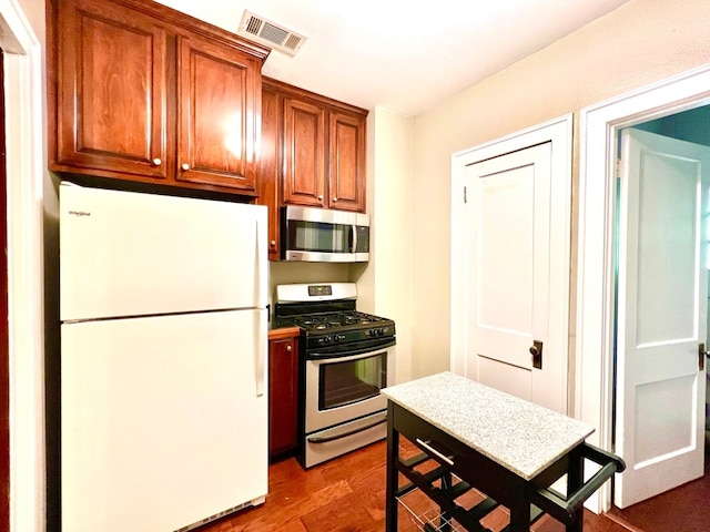 kitchen with stainless steel appliances and dark wood-type flooring