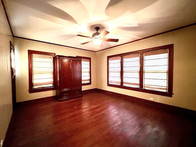 empty room featuring ceiling fan, ornamental molding, and dark hardwood / wood-style floors