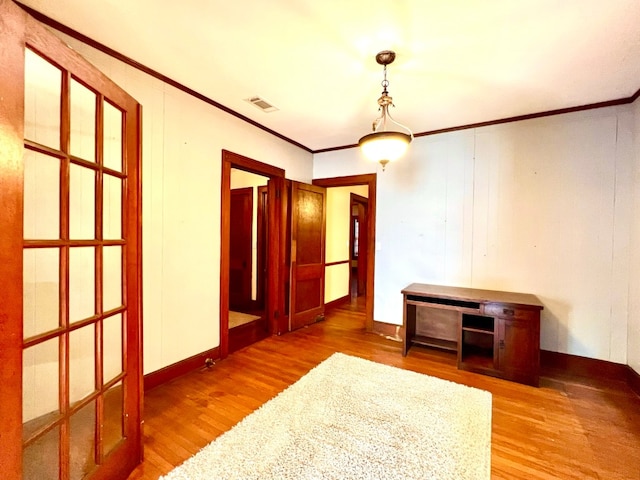 unfurnished room featuring wood-type flooring and ornamental molding