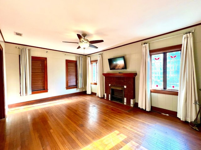 unfurnished living room with a fireplace, dark wood-type flooring, ornamental molding, and ceiling fan