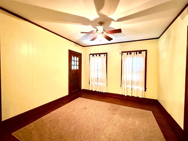 empty room featuring dark hardwood / wood-style floors, ornamental molding, and ceiling fan