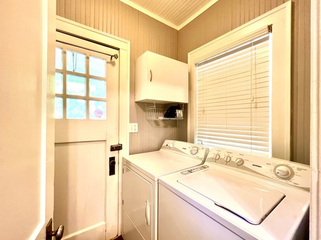 clothes washing area featuring crown molding and washing machine and dryer