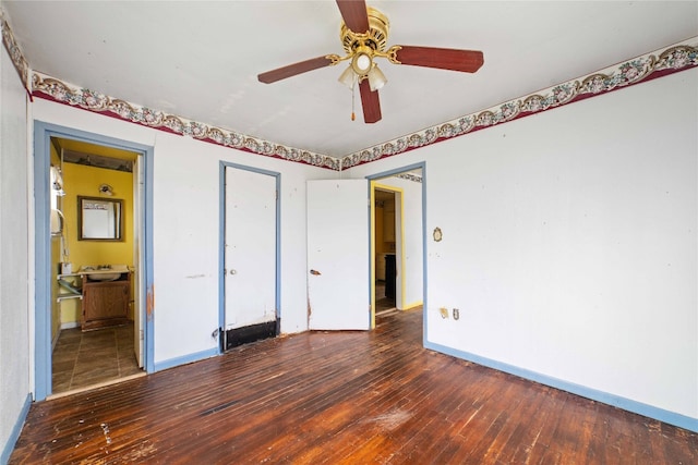 unfurnished bedroom with ceiling fan, connected bathroom, and dark wood-type flooring