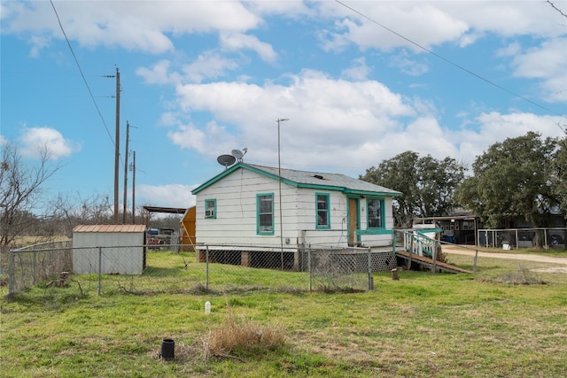 back of property with a lawn and a shed