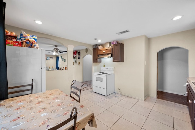 kitchen featuring light tile patterned flooring, ceiling fan, white appliances, and dark brown cabinetry