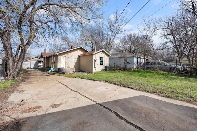 exterior space with central AC and a lawn