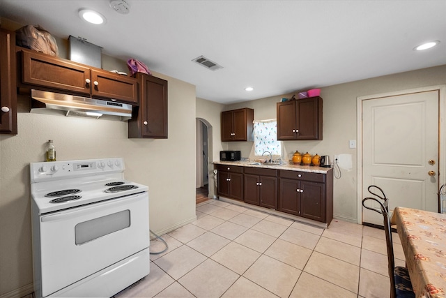 kitchen with light tile patterned floors, white electric stove, dark brown cabinets, and sink