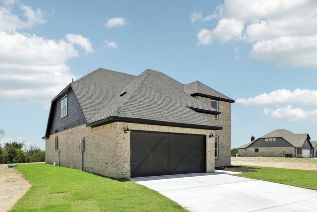 view of side of home featuring a garage and a lawn