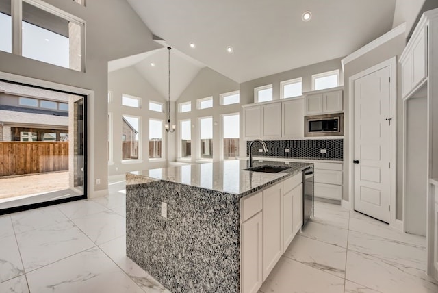 kitchen with marble finish floor, recessed lighting, appliances with stainless steel finishes, a sink, and high vaulted ceiling