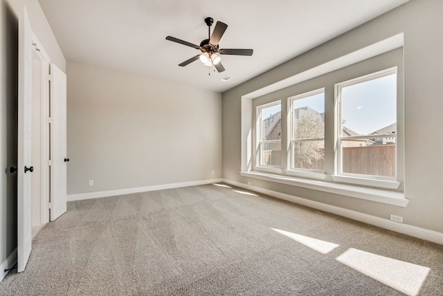 unfurnished room featuring a ceiling fan, carpet flooring, and baseboards