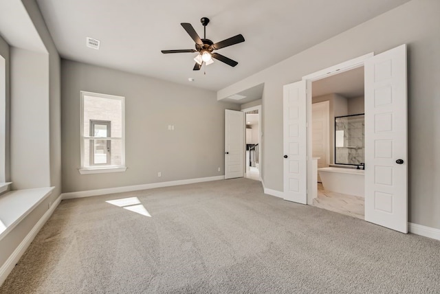 unfurnished bedroom featuring ensuite bathroom, carpet flooring, a ceiling fan, visible vents, and baseboards