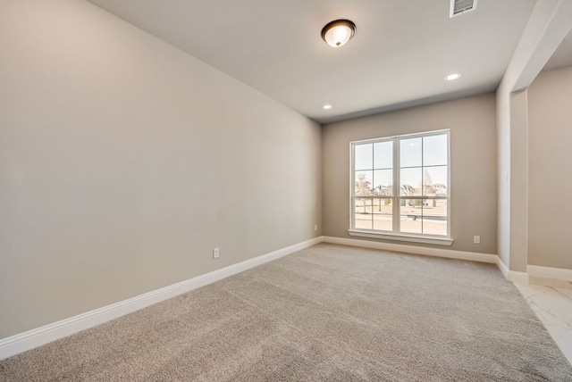 empty room with recessed lighting, light colored carpet, visible vents, and baseboards