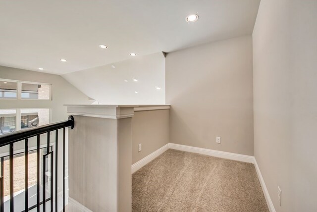 hallway with recessed lighting, carpet flooring, vaulted ceiling, an upstairs landing, and baseboards