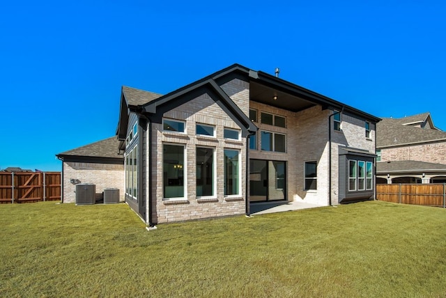 rear view of property featuring a fenced backyard, a lawn, and central air condition unit