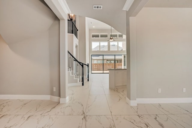 foyer featuring marble finish floor, visible vents, stairway, and baseboards