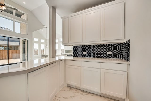 kitchen featuring marble finish floor, light countertops, and white cabinetry