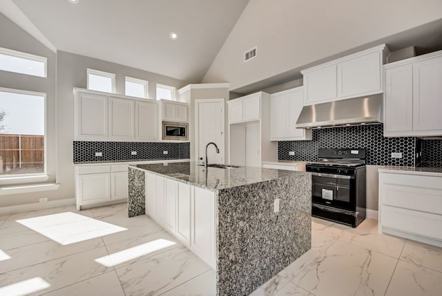 kitchen featuring black gas range, visible vents, stainless steel microwave, marble finish floor, and extractor fan