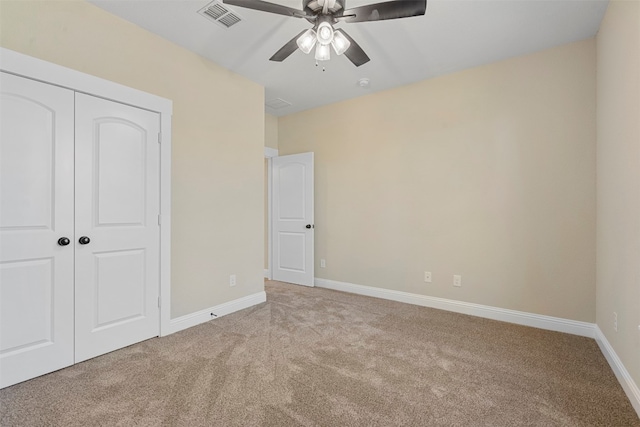 unfurnished bedroom with light carpet, a closet, and ceiling fan