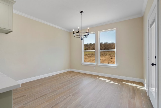 unfurnished room featuring light wood-type flooring, ornamental molding, and a chandelier