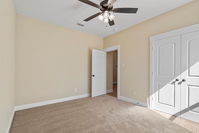 unfurnished bedroom with ceiling fan, a closet, and light colored carpet