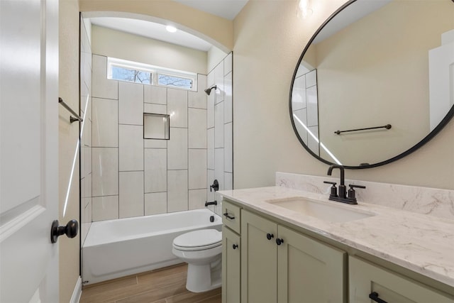 full bathroom with toilet, vanity, and tiled shower / bath