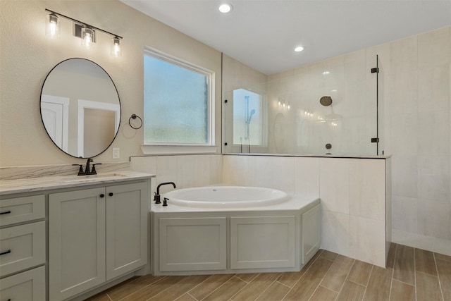 bathroom with vanity, shower with separate bathtub, and a healthy amount of sunlight