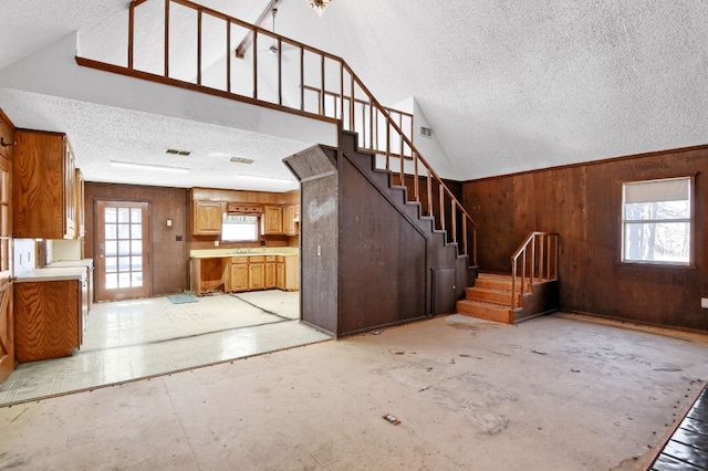 interior space with plenty of natural light, wood walls, and a textured ceiling