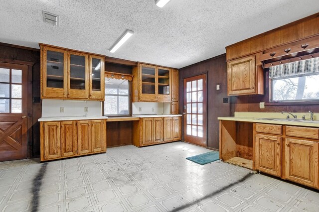 kitchen featuring wood walls, light tile floors, and a textured ceiling