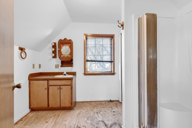 bathroom featuring lofted ceiling, vanity, and wood-type flooring