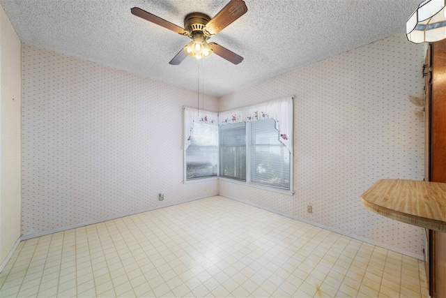 spare room with a textured ceiling, ceiling fan, and light tile floors