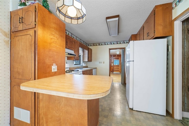 kitchen with white appliances, a textured ceiling, light tile floors, and kitchen peninsula