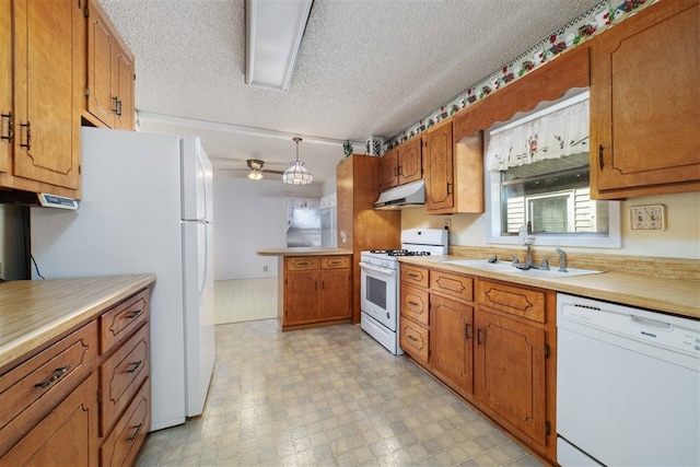 kitchen with white appliances, sink, light tile floors, decorative light fixtures, and a textured ceiling