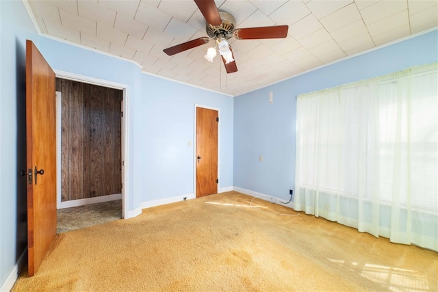 unfurnished bedroom with crown molding, a closet, light colored carpet, and ceiling fan