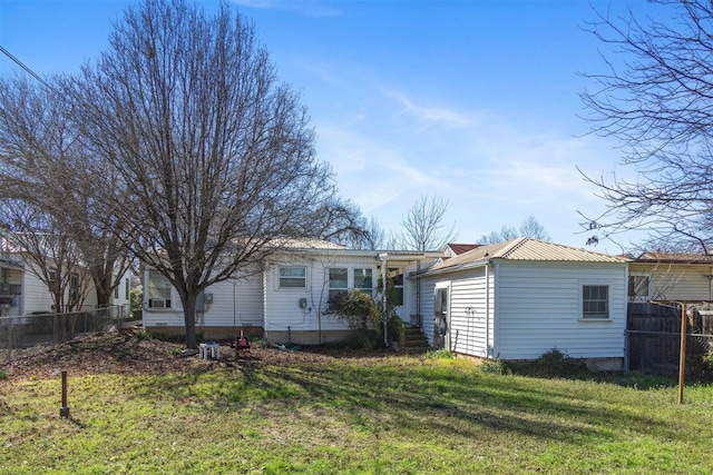 rear view of house featuring a yard