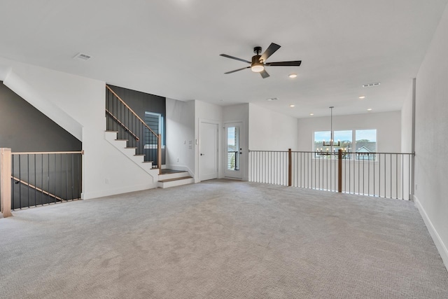 unfurnished room featuring ceiling fan with notable chandelier and carpet floors