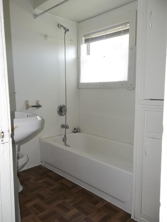 bathroom with shower / tub combination, parquet floors, and toilet