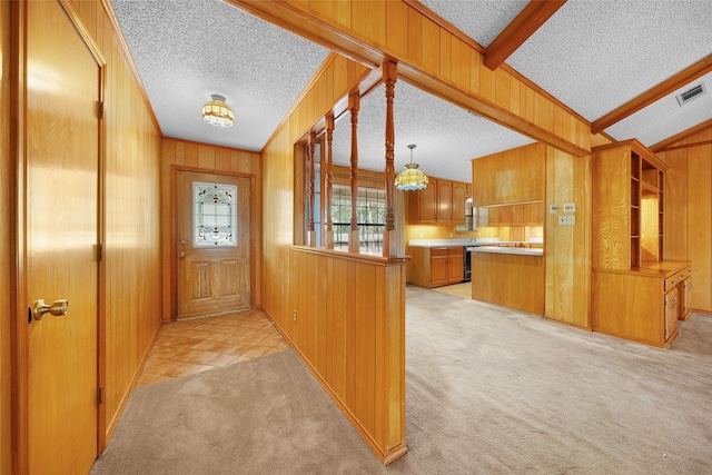 doorway to outside with light colored carpet, lofted ceiling with beams, wooden walls, and a textured ceiling