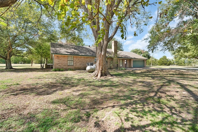 exterior space featuring a garage and a lawn