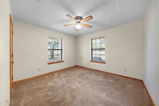 carpeted empty room featuring ceiling fan and a textured ceiling