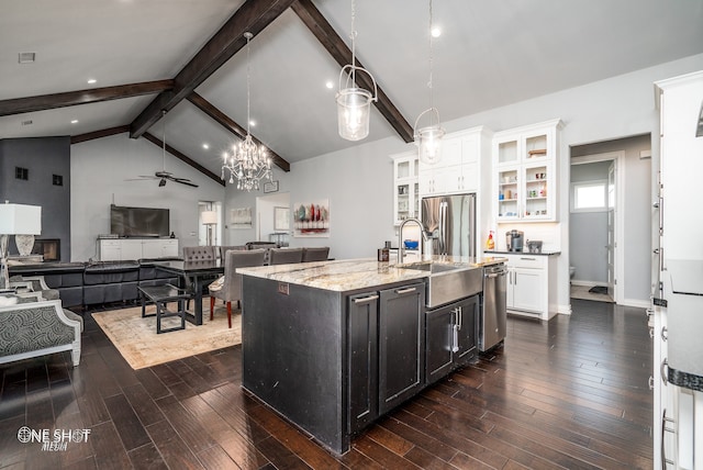 kitchen with stainless steel appliances, hanging light fixtures, vaulted ceiling with beams, an island with sink, and white cabinets