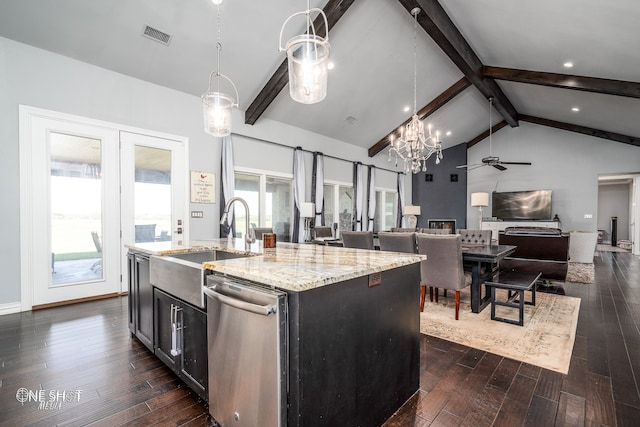 kitchen with stainless steel dishwasher, decorative light fixtures, ceiling fan, and a center island with sink