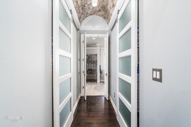 hallway featuring crown molding, lofted ceiling, and brick ceiling