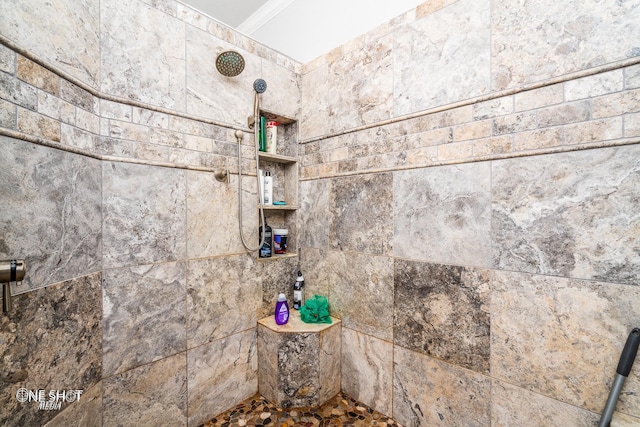interior details featuring a tile shower and ornamental molding