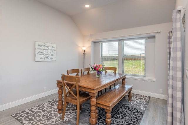 dining space featuring vaulted ceiling and hardwood / wood-style flooring