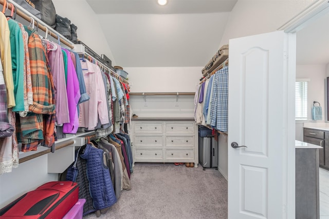 walk in closet featuring light colored carpet and vaulted ceiling