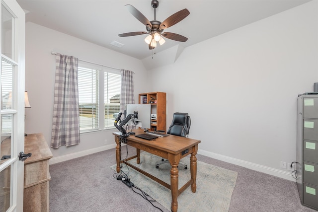 carpeted office space featuring ceiling fan, visible vents, baseboards, and vaulted ceiling