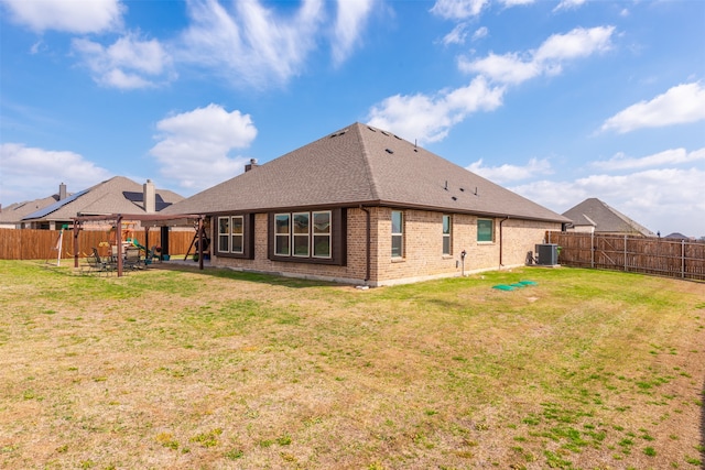 rear view of house featuring central AC unit, a yard, and a patio