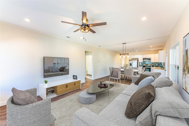 living room with ceiling fan and light wood-type flooring