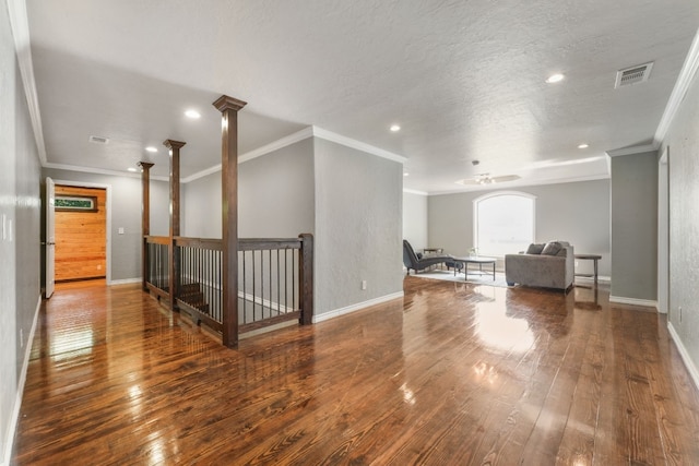 interior space with ceiling fan, dark wood-type flooring, a textured ceiling, and crown molding