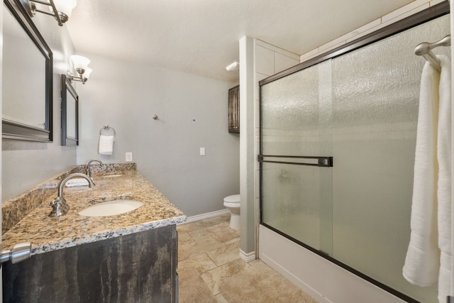 full bathroom with combined bath / shower with glass door, toilet, tile floors, and dual bowl vanity